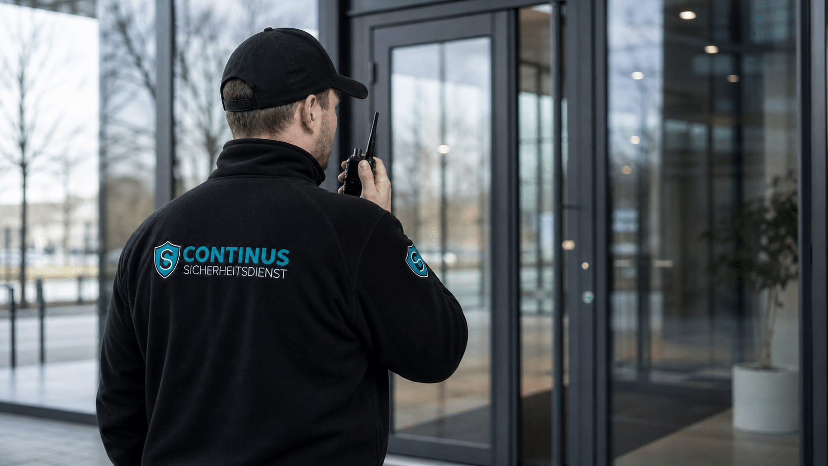 Sicherheitsmitarbeiter mit Funkgerät sichert den Eingang eines modernen Firmengebäudes mit Glasfront